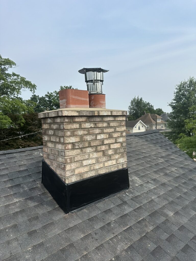 Completed chimney tan brick new black flashing stainless cap NJ