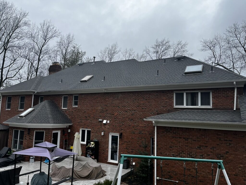 Three new skylights large brick home dark gray shingles rear view NJ